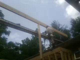 Carpenter setting a ridge beam over a new addition frame — Ice Dam Removal by Roofing Brothers in Larue