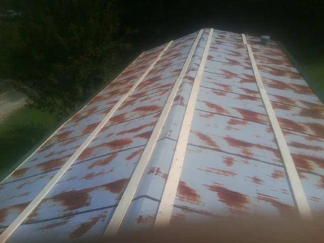 Rusted metal roof panels with new wood purlins before replacement — Storm Damage Roof Repair in Larue by Roofing Brothers