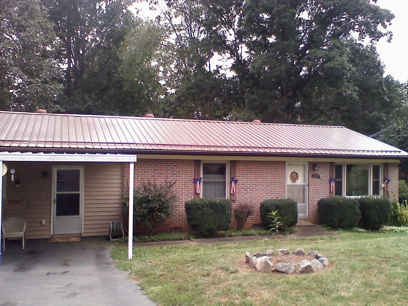 Bronze metal roof and carport on a brick ranch home — Roof Repair work by our crew in Larue
