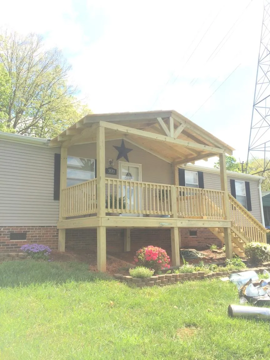 New gabled porch roof and deck railing added to a ranch home in Larue
